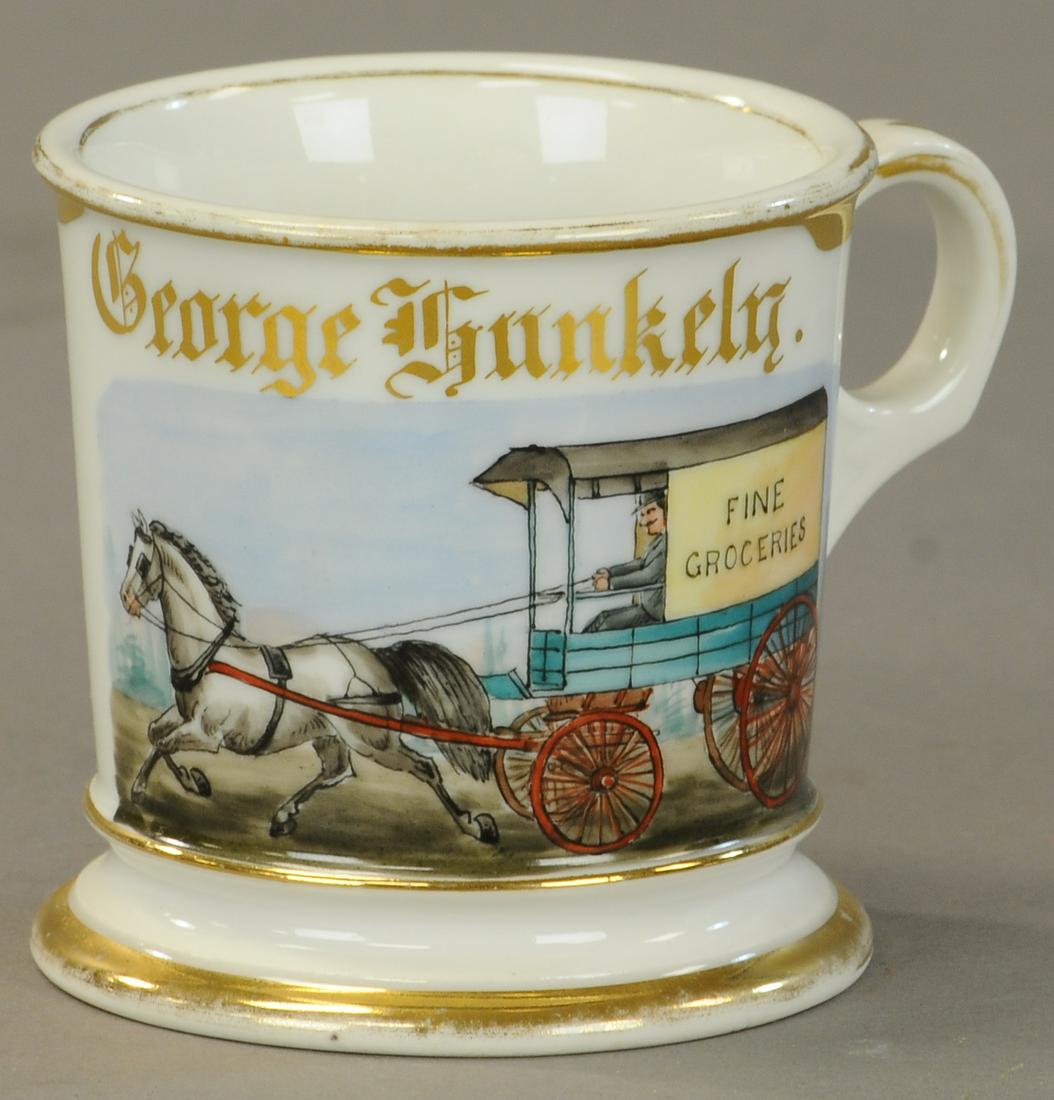 FINE GROCERY DELIVERY WAGON SHAVING MUG: 2461. FINE GROCERY DELIVERY WAGON SHAVING MUG | “Fine Groceries” nice clean mug no damage slight gold wear to rims name full. - | As Noted. | $200 - $400 | Provenance: Sam Downey Collection.