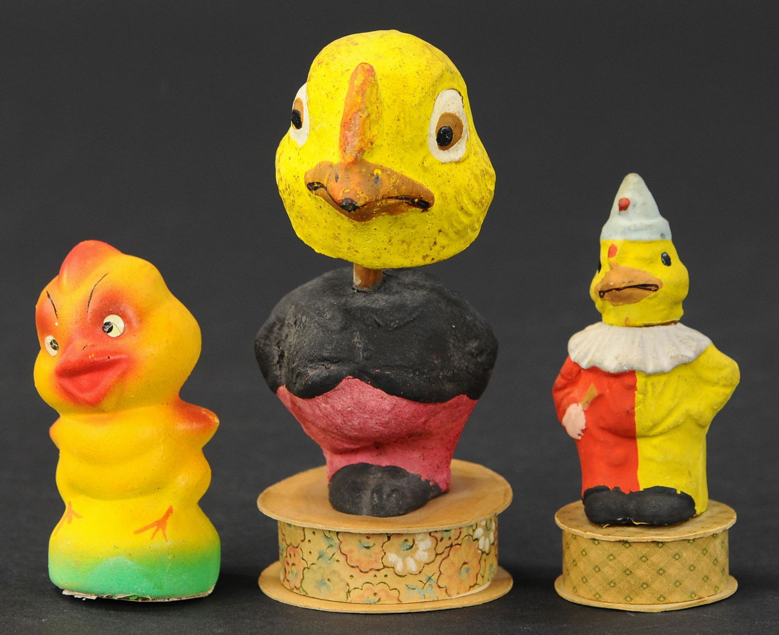 THREE EASTER CHICK CANDY CONTAINERS: 2485. THREE EASTER CHICK CANDY CONTAINERS | Large nodder, chick on candy box [head re-glued], along with post-war yellow chick. 3.5" -6.5". | (Good Condition) | $150 - $300 | Provenance: Sam Downey Co