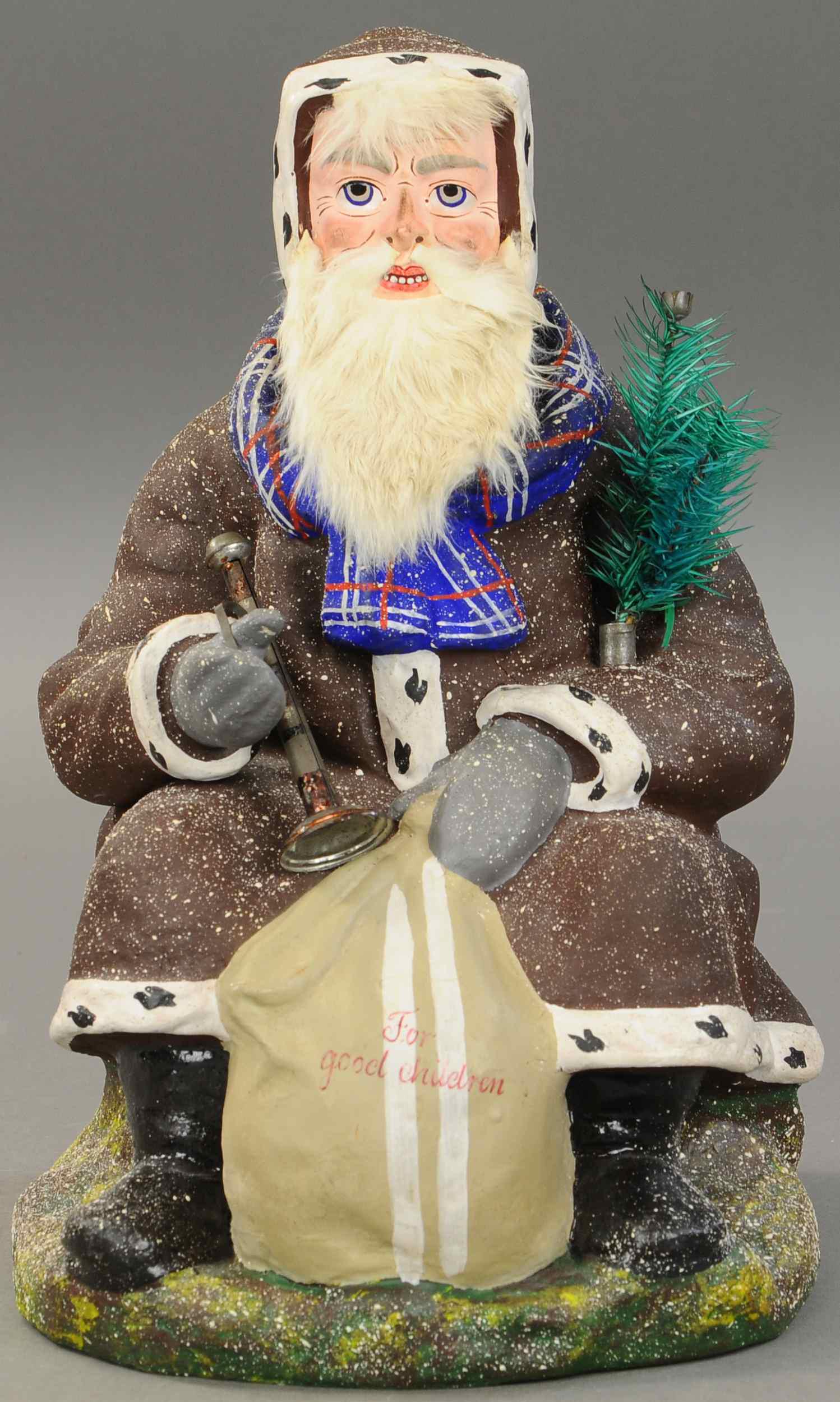 SITTING SANTA CLAUS NODDER: 2542. SITTING SANTA CLAUS NODDER | Post war Germany, possibly a prototype nodding Santa, composition throughout, he is sitting on a forest rock, holding toy sack marked "For Good Children," dressed in