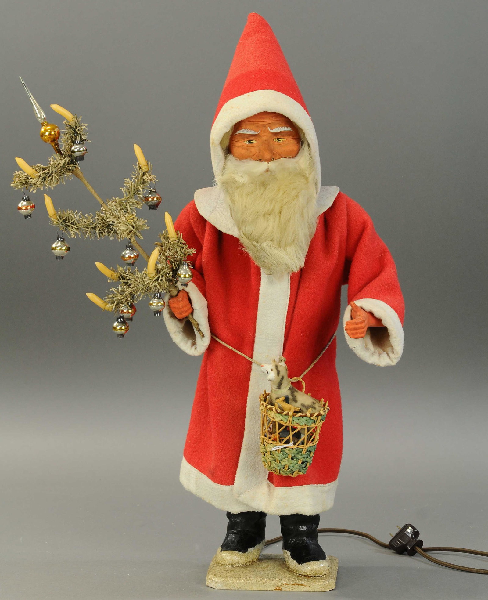 ELECTRONICALLY OPERATED NODDING SANTA: 2564. ELECTRONICALLY OPERATED NODDING SANTA | Large Santa Claus figure, composition head w/wooly beard, wearing a long red felt robe trimmed in white, basket of toys at his waist and candle lit, paper