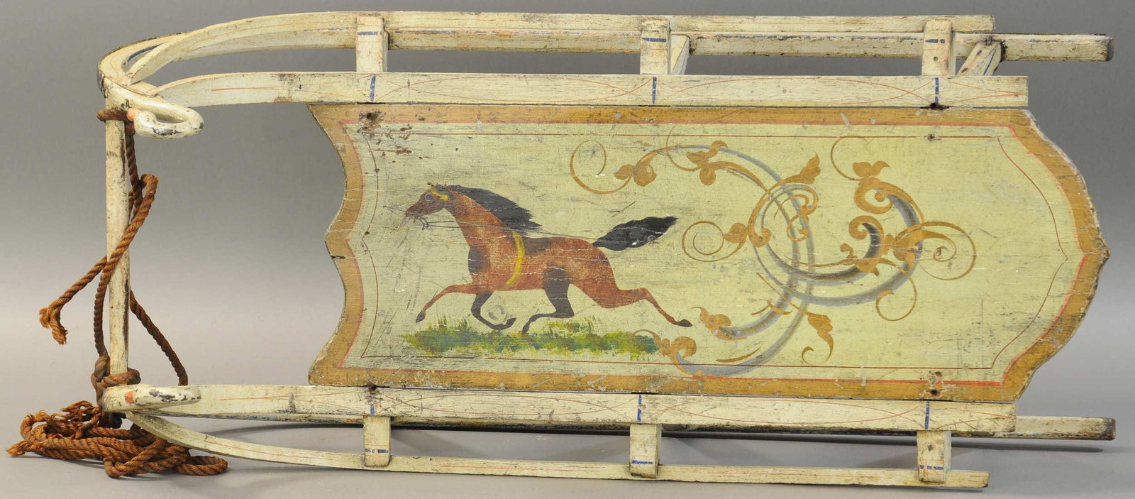 EXCEPTIONAL FOLKY SWAN FINIAL SLED: 2579. EXCEPTIONAL FOLKY SWAN FINIAL SLED | Early, paint decorated sled w/prancing horse, green background w/gold borders, cast iron swan finials, a good strong image. 33" l. | (VG - Exc. Cond.) | $1,5