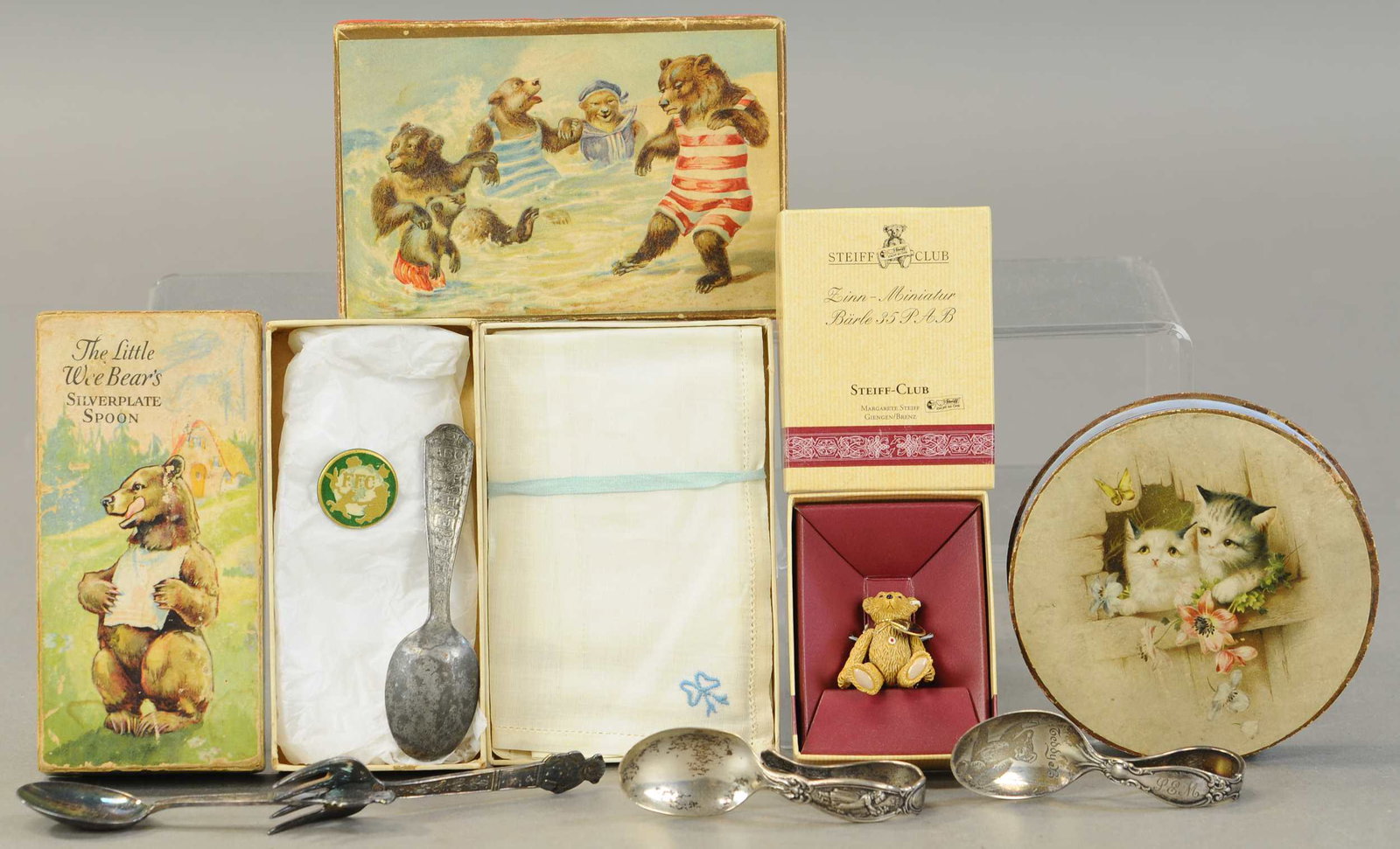 THREE TEDDY BEAR BOXES AND SPOONS: 343. THREE TEDDY BEAR BOXES AND SPOONS| Lot includes a hankie box, "Wee Bears" spoon box w/spoon, newer "Steiff Club" box w/tiny bear, kitten box, and silver-plate three spoons & one fork.| 4" - 6"| (