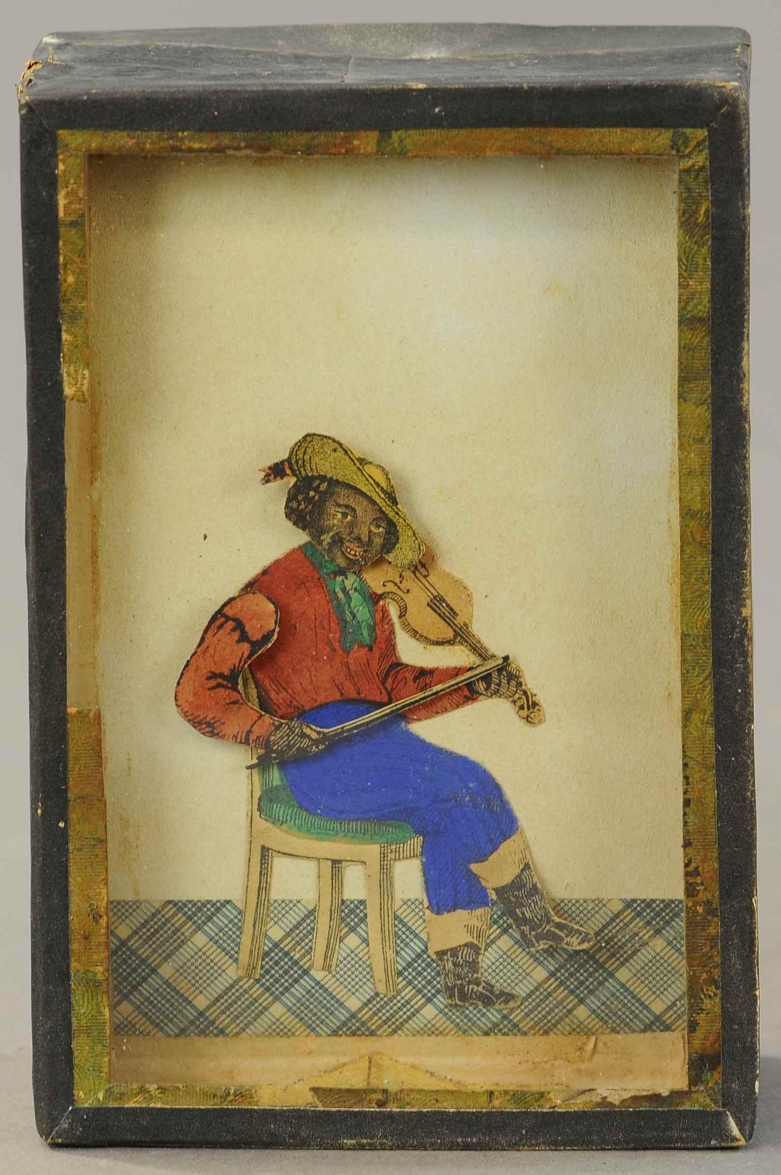 EARLY SAND TOY WITH BLACK MAN: 368. EARLY SAND TOY WITH BLACK MAN| Seated man playing a violin, head and arm move sporadically, has been re-taped around the perimeter.| 6" h.| (Good Cond.)| $200 - $400
