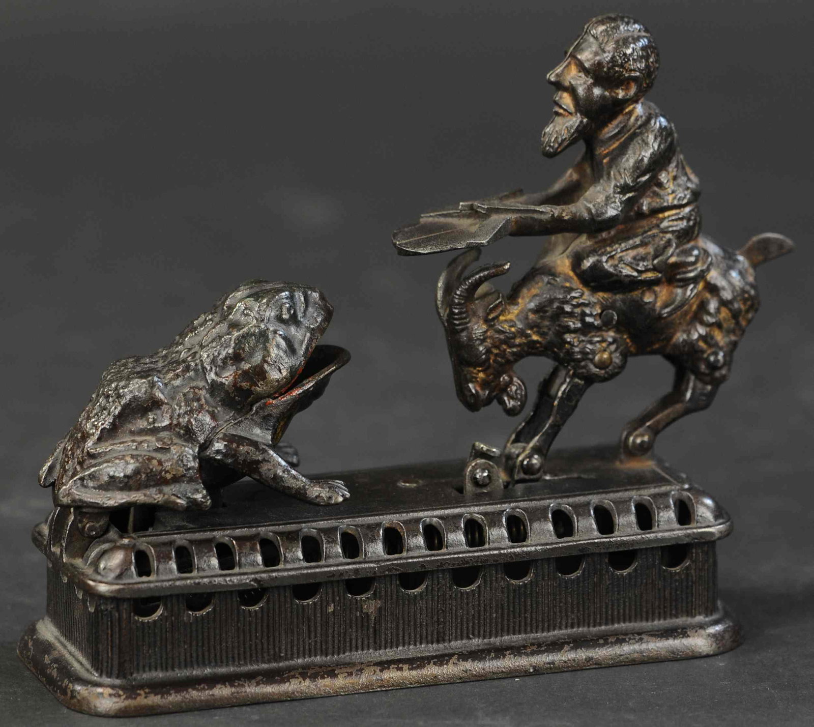 INITIATING BANK SECOND DEGREE MECHANICAL BANK: 97. INITIATING BANK SECOND DEGREE MECHANICAL BANK | Mechanical Novelty Works., the second variation of a familiar bank design, as goat springs forward, coin is deposited into frog's mouth and into bas