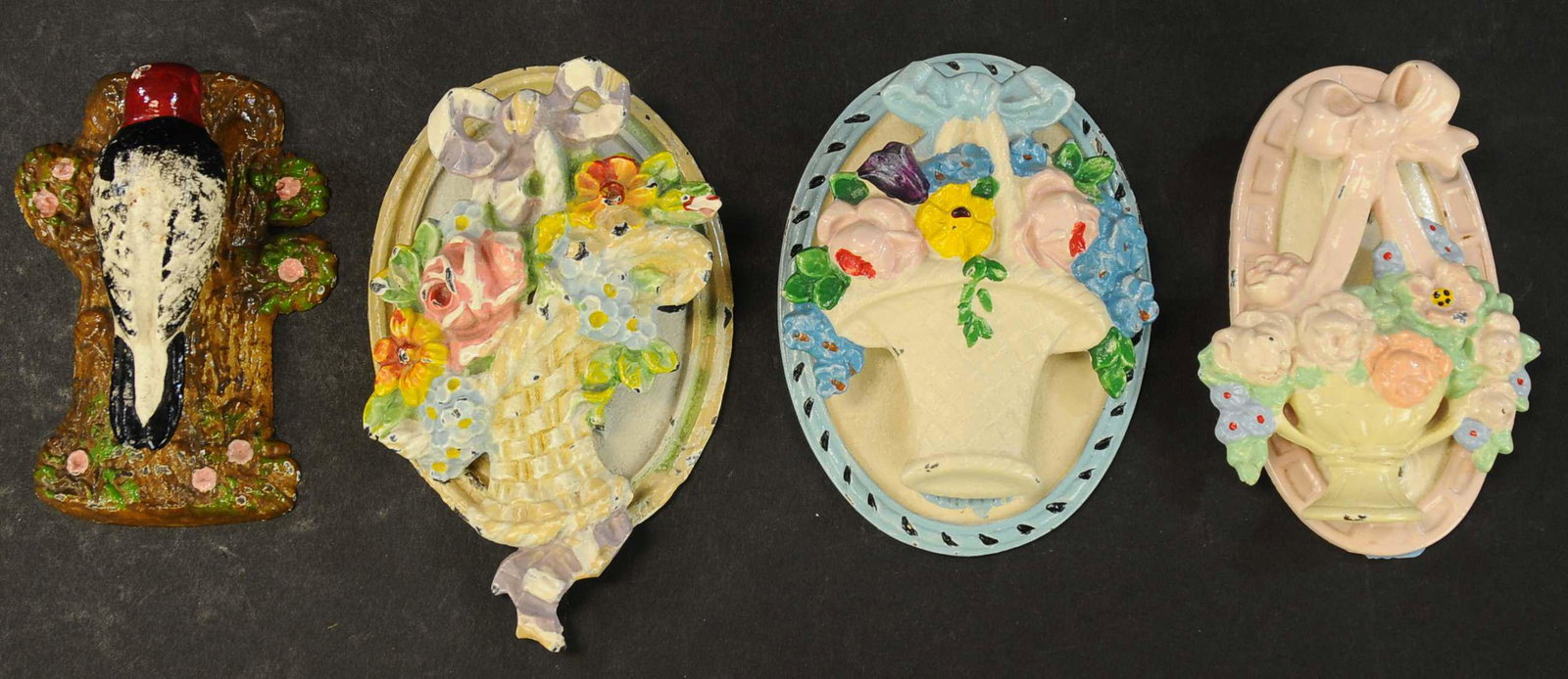 FOUR HUBLEY CAST IRON DOORKNOCKERS: 317. FOUR HUBLEY CAST IRON DOORKNOCKERS | Includes three pastel colored flower baskets and a woodpecker on a tree trunk with floral accents. 3" - 3.25" h. | (Excellent to Pristine Condition) | $200 - 