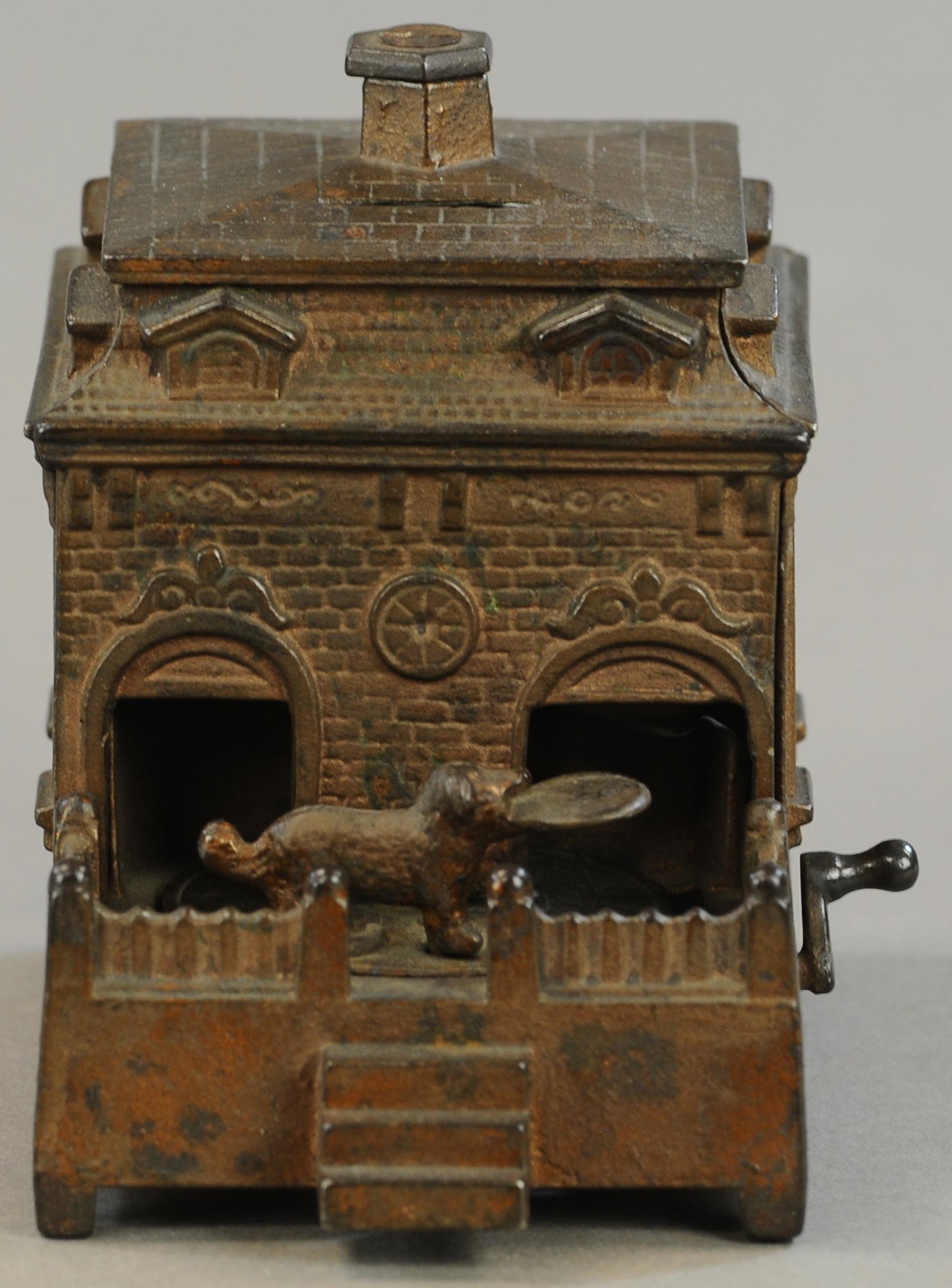 DOG ON TURNTABLE MECHANICAL BANK: 205. DOG ON TURNTABLE MECHANICAL BANK | Lever is replaced with slipping gear at underside, paint in All Original Condition. | $200 - $400