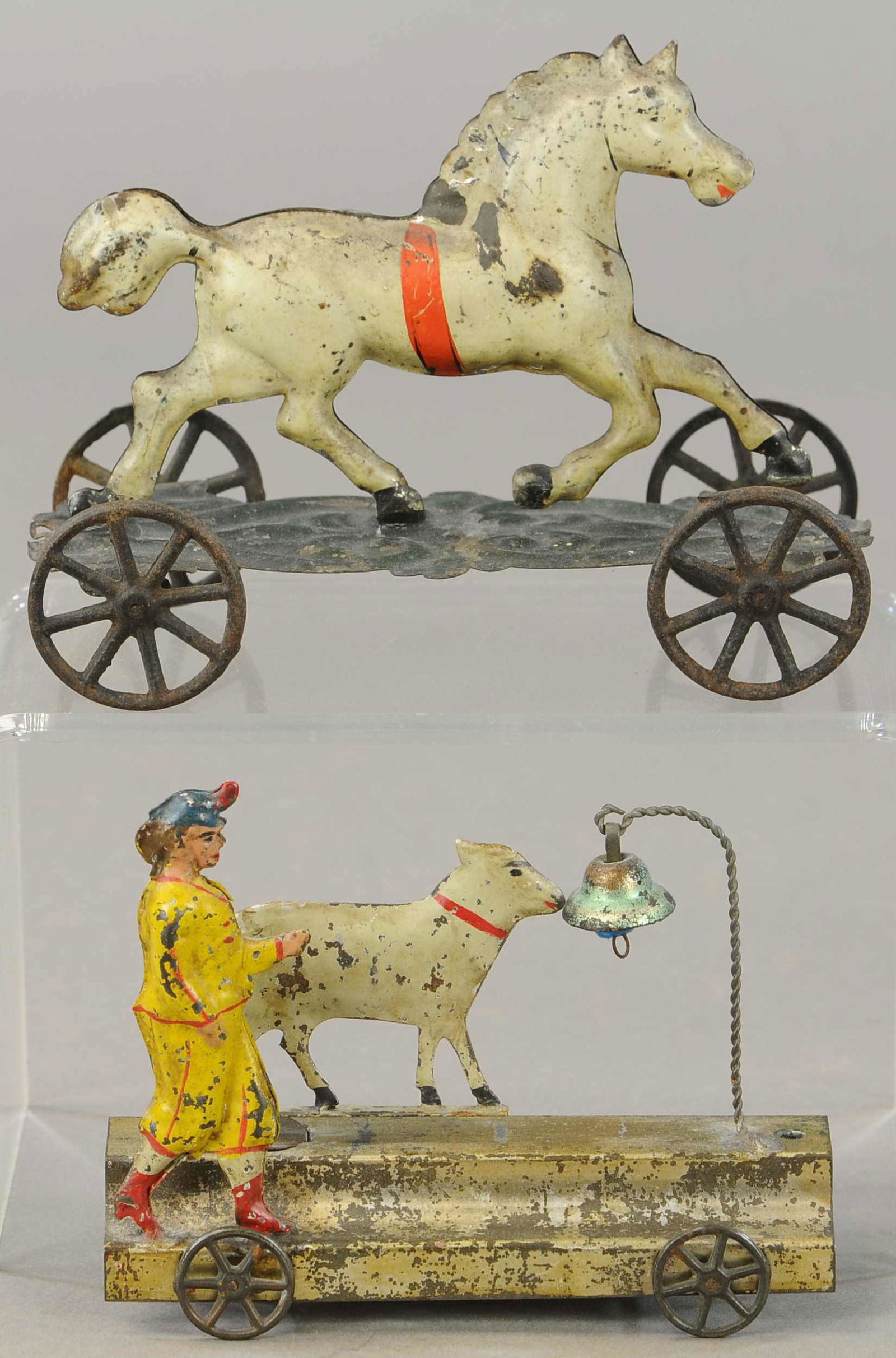 TWO EARLY AMERICAN PLATFORM TOYS: 221. TWO EARLY AMERICAN PLATFORM TOYS | 5.5 - 6.5" l. | Horse on platform is in All Original Condition, Goat and figure are repainted. | $200 - $400