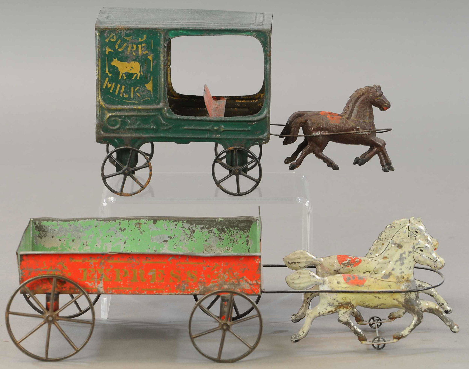 TWO LARGE AMERICAN TIN HORSE CARTS: 269. TWO LARGE AMERICAN TIN HORSE CARTS | 11" - 15" l. | Horses on express wagon are touched up and cart has some splits seams, Original horses are added to pure milk wagon otherwise in All Original C