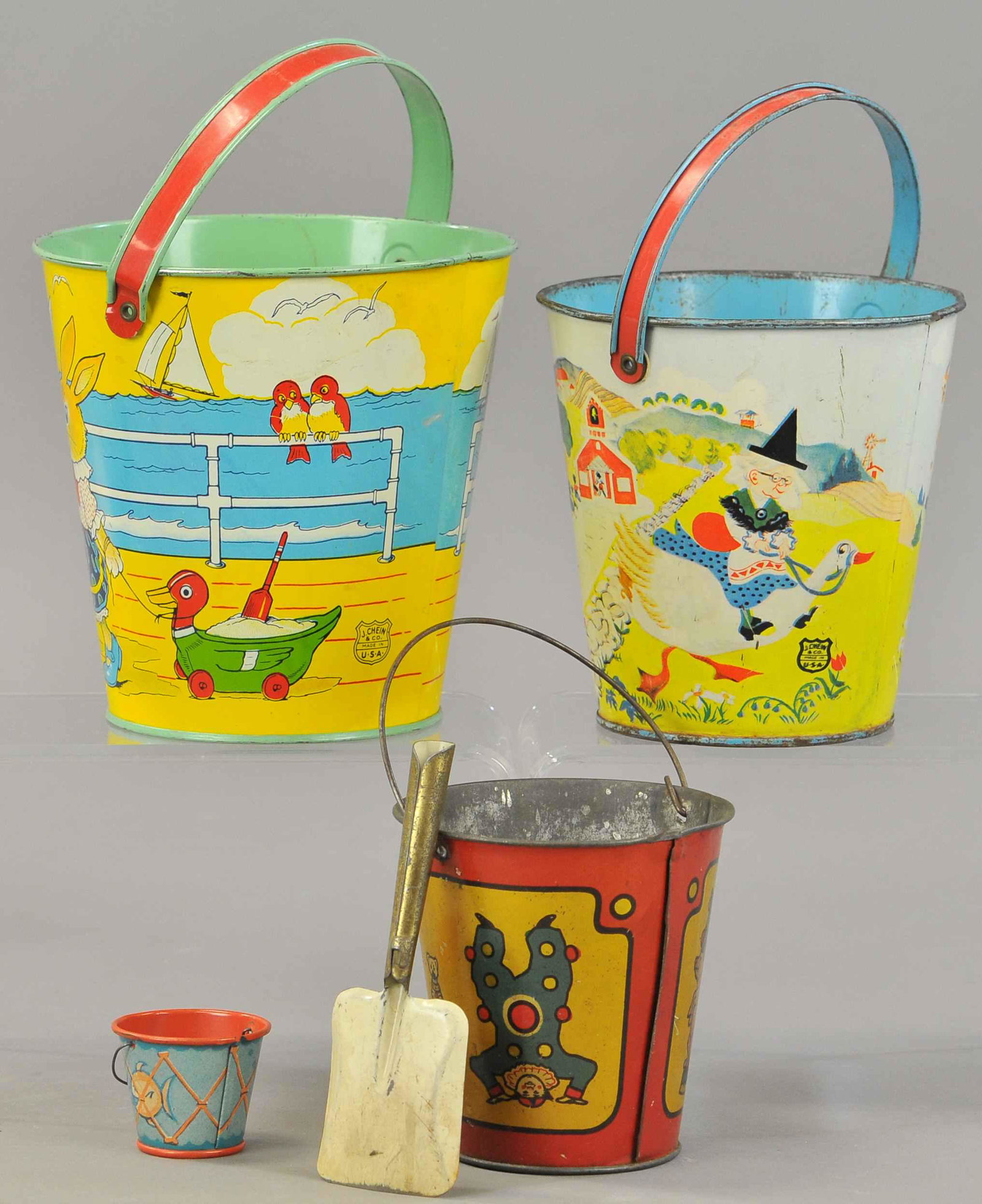 FOUR SAND PAILS: 356. FOUR SAND PAILS | An early bail handle tin, two J. Chein tins along with a tiny bail handle pail. | 1.5" - 6" h. | (Good-VG Cond.) | $100 - $200