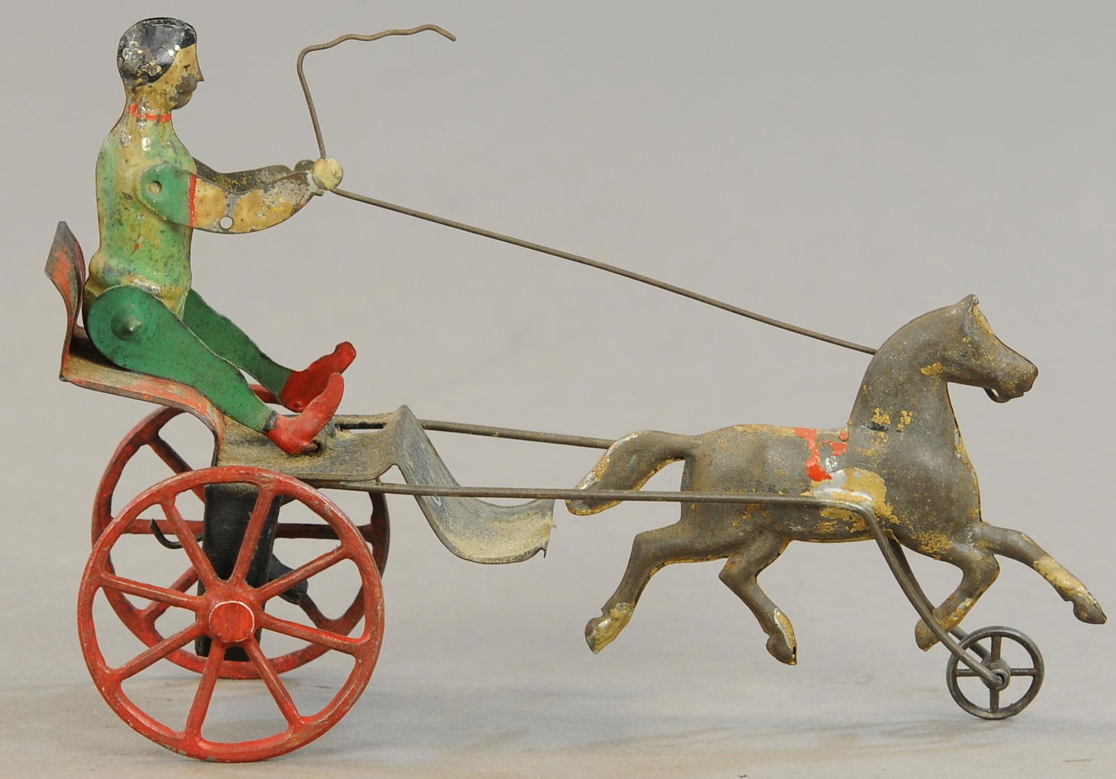 UNUSUAL HORSE DRAWN CARRIAGE TOY: 145. UNUSUAL HORSE DRAWN CARRIAGE TOY | 7" l. | Arms and legs of figure repainted. | $100 - $200