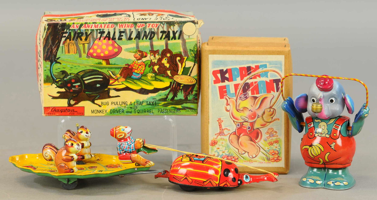 PAIR OF BOXED JAPANESE WIND-UPS TOYS: 103. PAIR OF BOXED JAPANESE WIND-UPS TOYS | Fairy Tale Land Taxi is made by Cragstan. | 6x12" l. | Elephant has touch-ups to reds, otherwise in All Original Condition. | $150 - $300