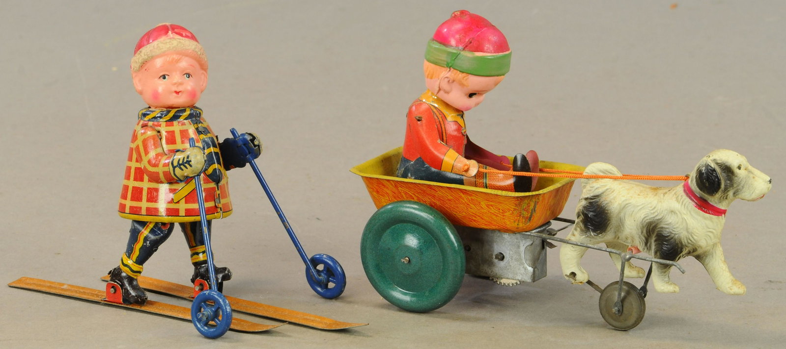TWO CELLULOID HEAD WINTER TOYS: 130. TWO CELLULOID HEAD WINTER TOYS | 7" l. | Skier boy has split to celluloid at neck, boy with dog needs wind-up adjustment, All Original Condition. | $250 - $500