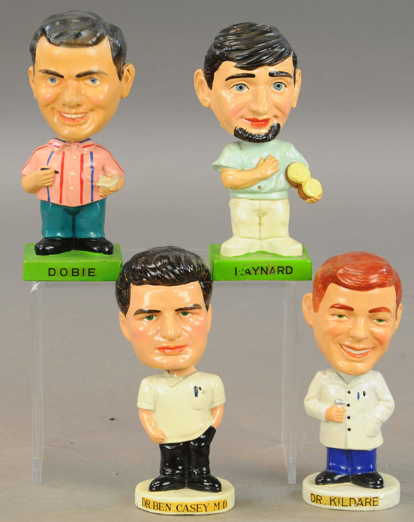 DOBIE GILLIS, MAYNARD KREBS, DR. KILDARE & BEN: 244. DOBIE GILLIS, MAYNARD KREBS, DR. KILDARE & BEN | CASEY BOBBLEHEADS | 7" h. | Two cracks to left side of Maynard's face, small crack at back of head of Dr. Kildare. | $200 - $400