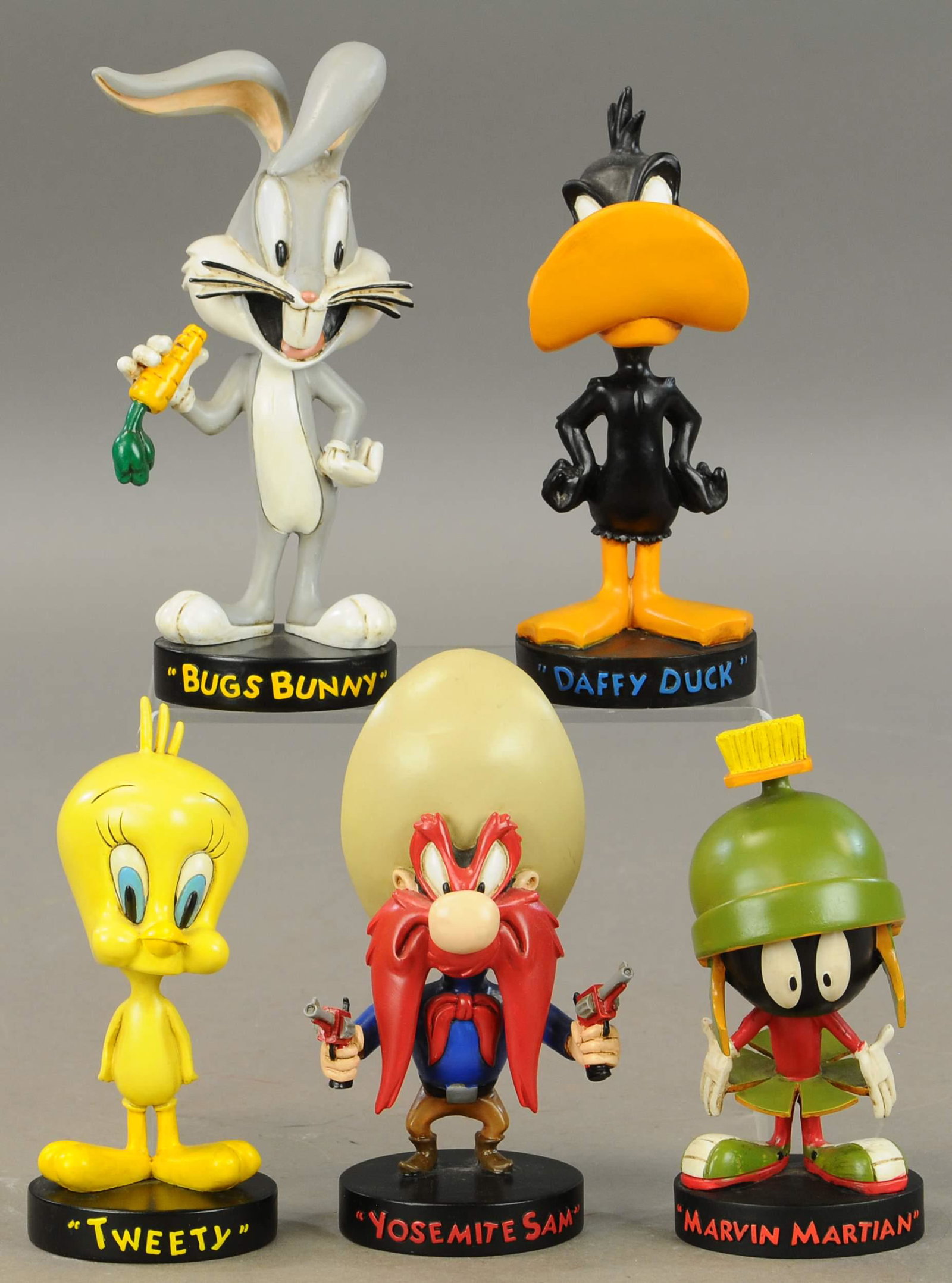GROUPING OF WARNER BROTHERS BOBBLEHEADS: 258. GROUPING OF WARNER BROTHERS BOBBLEHEADS | Includes Tweety, Daffy Duck, Bugs Bunny, Yosemite Sam & Marvin Martian. | 7" - 8" h. | (Exc. Cond.) | $150 - $300