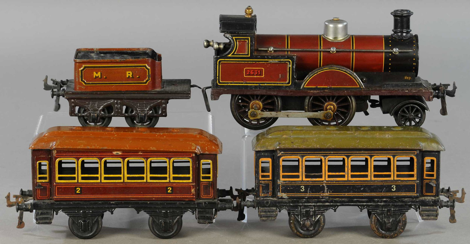 BING MIDLAND RAILWAY LOCOMOTIVE AND CARS: 305. BING MIDLAND RAILWAY LOCOMOTIVE AND CARS | Gauge 1, clockwork. | Loco & tender 14" l. | Loco smoke stack loose, minor touch-ups to chips on Loco, otherwise All Original Condition. | $200 - $400