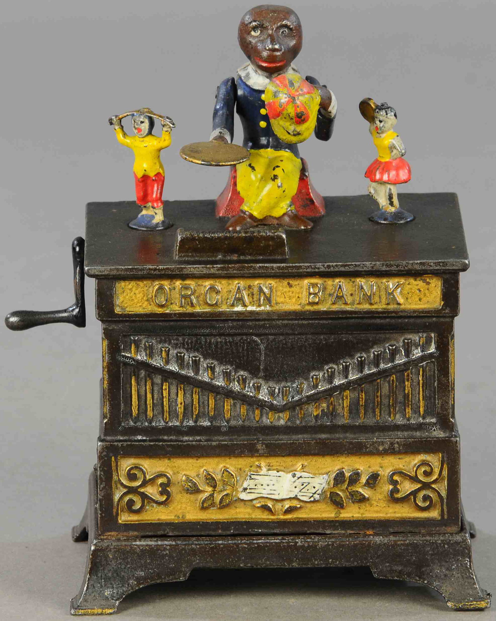 ORGAN BANK MECHANICAL BANK - BOY/GIRL: 366. ORGAN BANK MECHANICAL BANK - BOY/GIRL | 7" h. | Replaced crank, chip to corner of side panel, otherwise in All Original Condition. | $250 - $500
