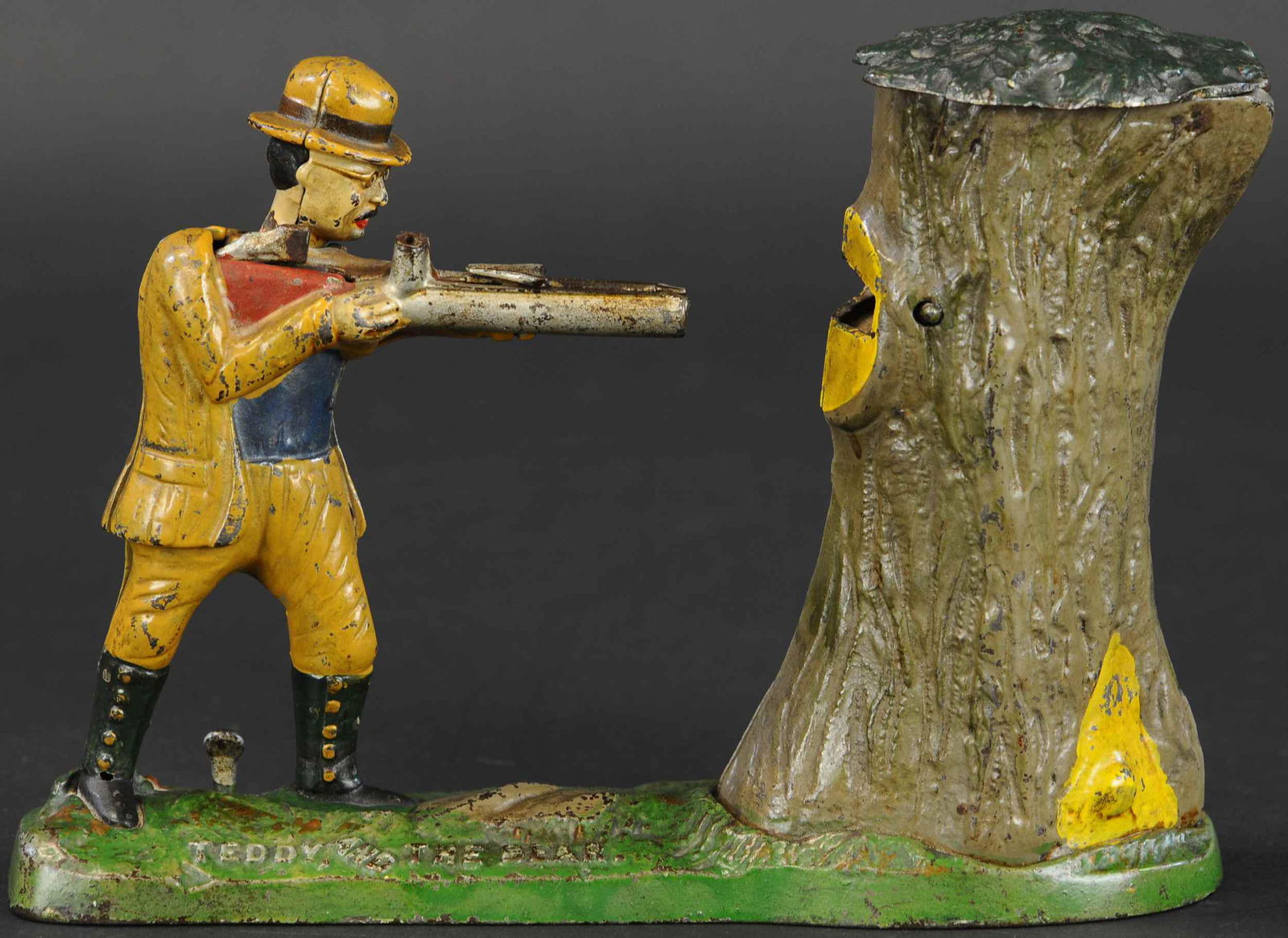 TEDDY AND THE BEAR MECHANICAL BANK: 234. TEDDY AND THE BEAR MECHANICAL BANK | J & E Stevens Co., a very popular shooting bank which depicts Teddy Roosevelt big game hunting a bear in a tree. | (Excellent Condition) | $1,200 - $1,800