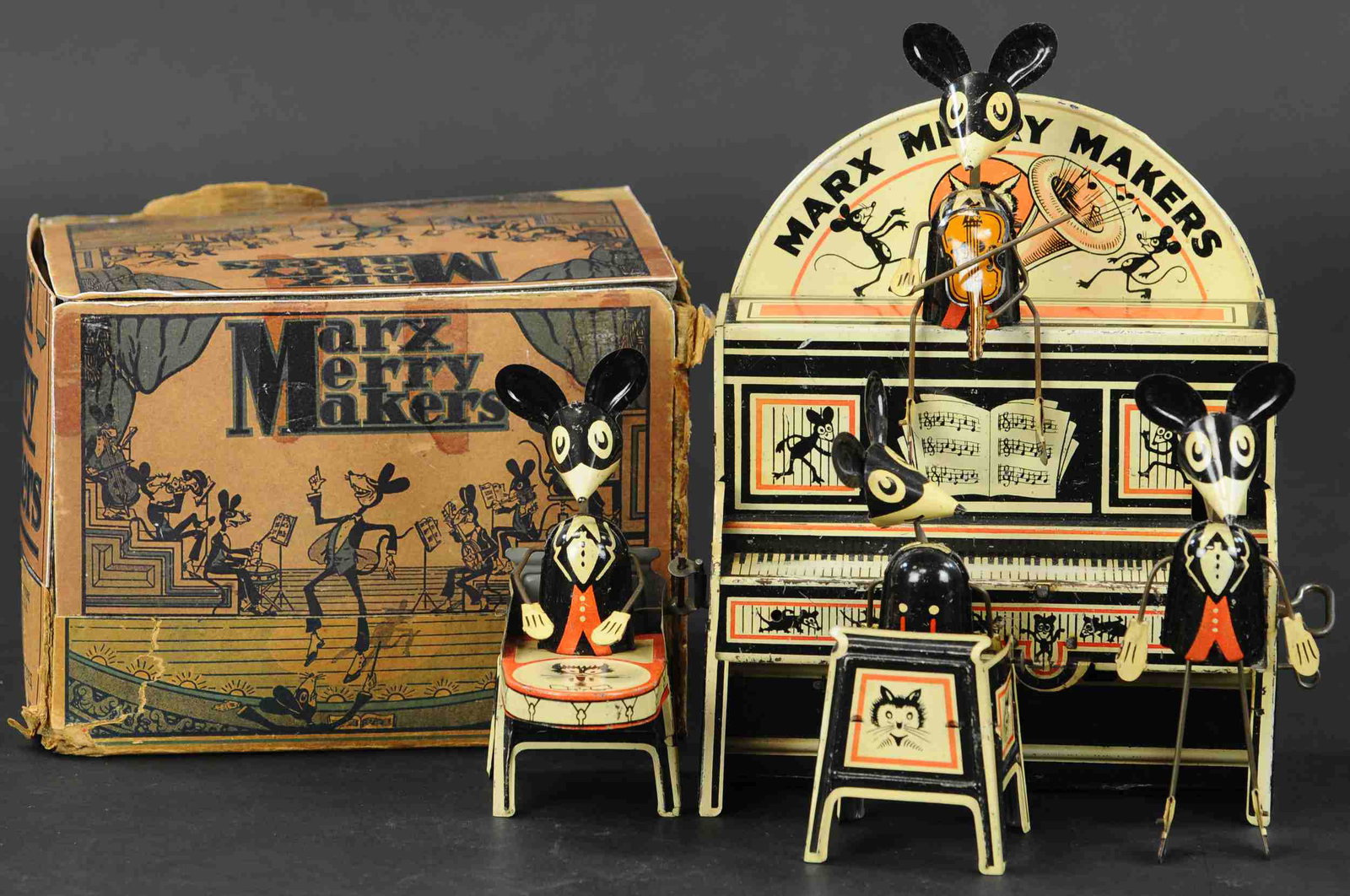 BOXED MARX MERRY MAKERS BAND: 353. BOXED MARX MERRY MAKERS BAND | Deluxe version with marquee behind piano and violinist seated atop instead of the conductor. | 9" l. | Half of box is repaired and replaced, toy in (Excellent Condi