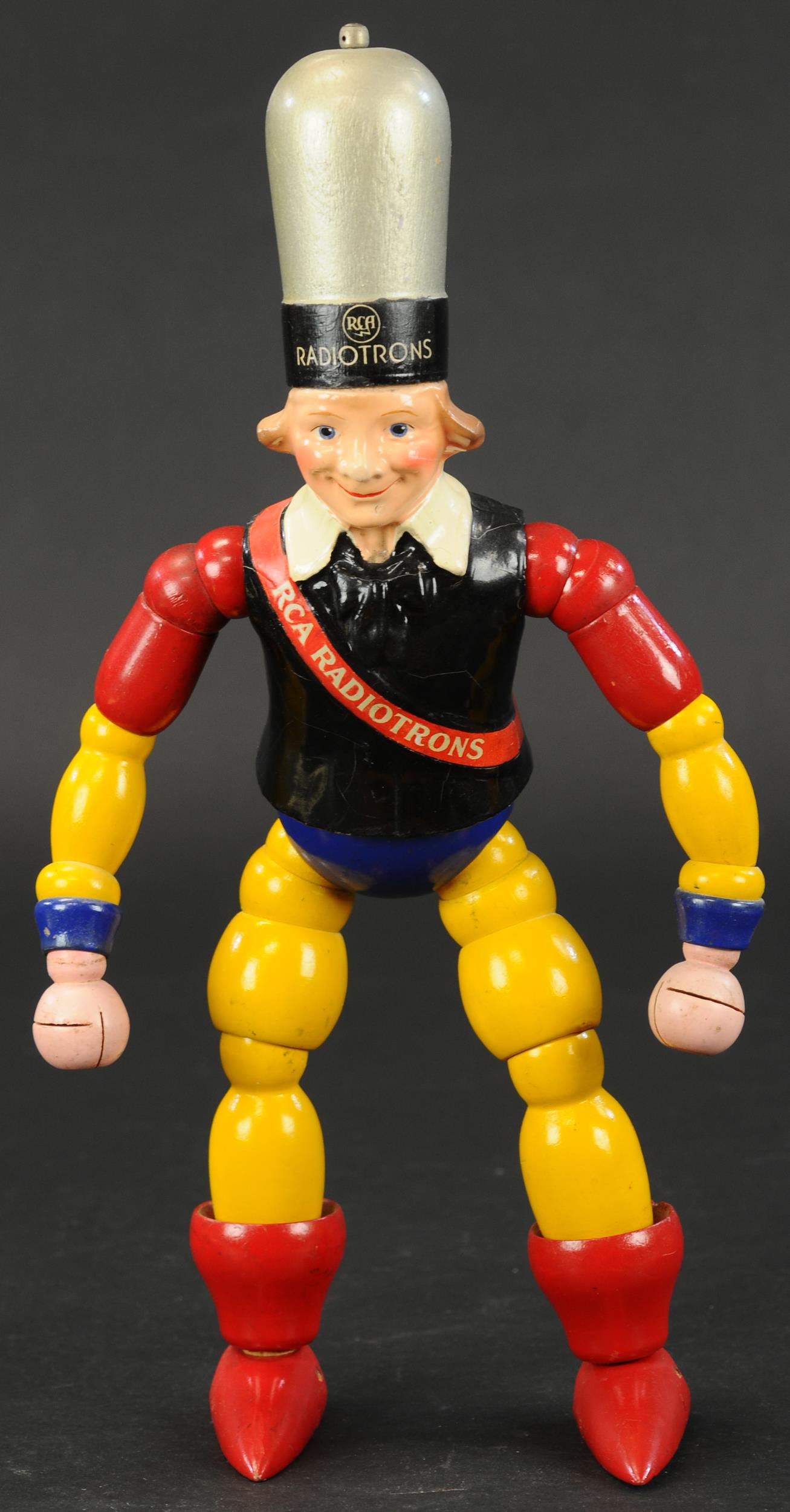 RCA RADIOTRONS ADVERTISING MAN: 416. RCA RADIOTRONS ADVERTISING MAN | Design attributed to Maxfield Parrish. Provenance: Keith Kaonis Collection. | 15" h. | Some minor crazing to jacket, otherwise in (Excellent Condition) | $500 - $