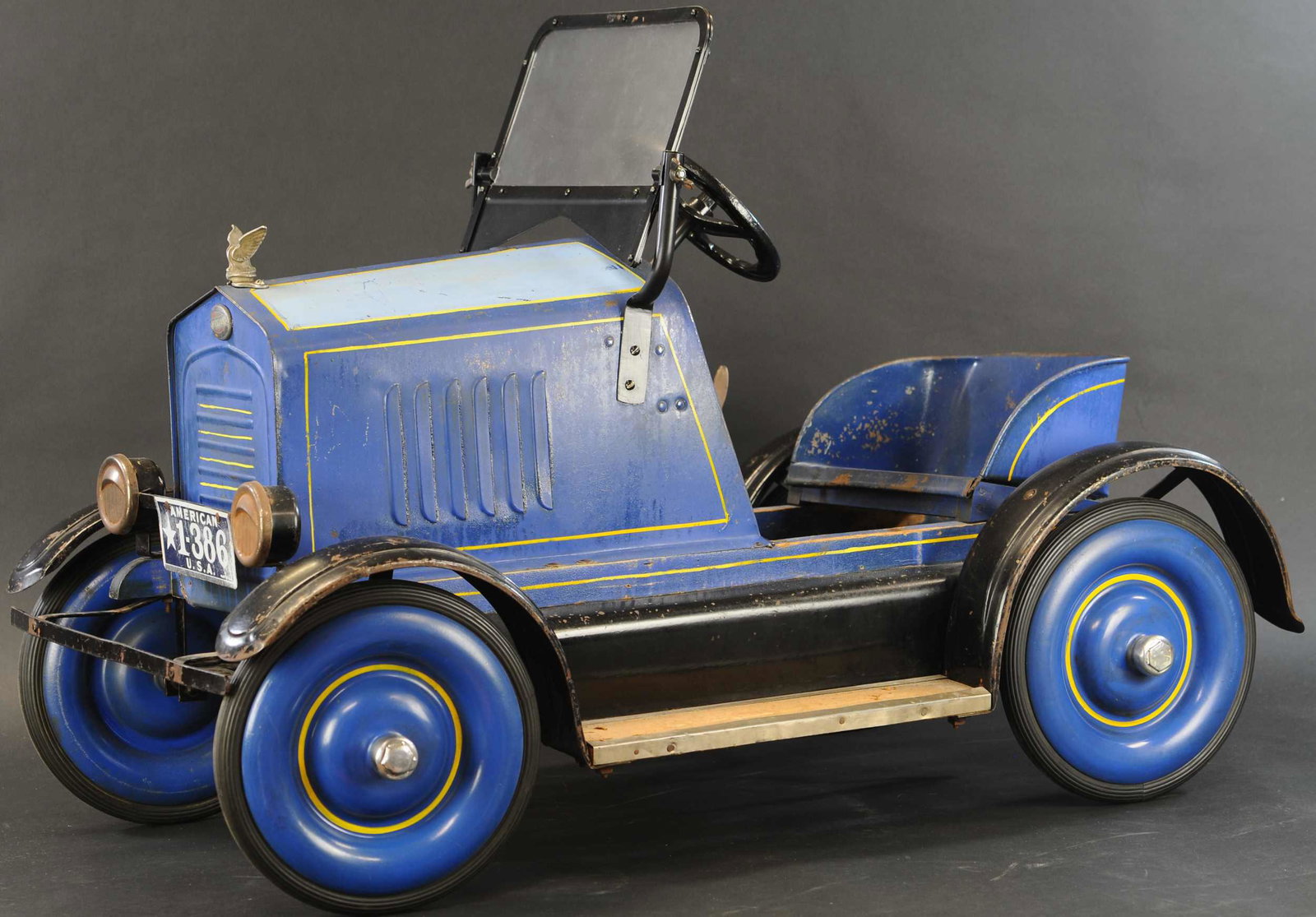 TOLEDO BLUE STREAK PEDAL CAR: 527. TOLEDO BLUE STREAK PEDAL CAR | Full fender c. 1930's, car with spring ride, original two toned paint and stenciling, all accessories appear to be original with replacement to complete windshield/