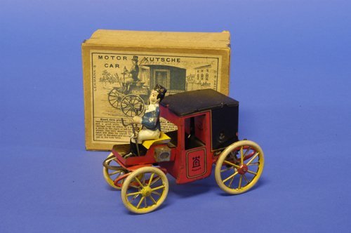 LEHMANN BOXED MOTOR CAR: Germany, lithographed tin, one of the first Lehmann toy autos, an obvious horseless carriage converted to motorized power, seated driver, enclosed coach, spoke wheels, done in bright red and black bod