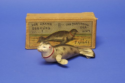 LEHMANN BOXED PERFORMING SEA LION: Germany, lithographed tin, well detailed full figure, natural grey and white colors, clockwork action, allows arms and tail to move about. 7 1/2'' long.