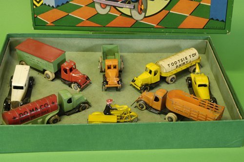 TOOTSIETOY DELUXE TRUCKS SET: Consists of eight pieces, including a wrecker, Dairy tanker, cyclist with side cart, Domaco Oil tanker, Dairy panel van, stake truck, Long Distance Truck and a City Fuel Company open bed truck; bright