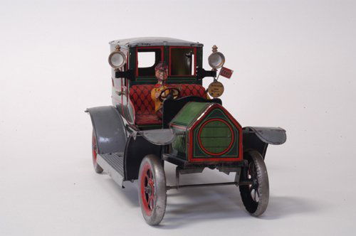 HANS EBERL TAXI CAB: Germany, c.19101914, an eye catching color scheme and extensive detailing overall, open chauffeur's area and enclosed passengers' seating, side lamps are cast, seated figure, clockwork driven. 13 1/2'