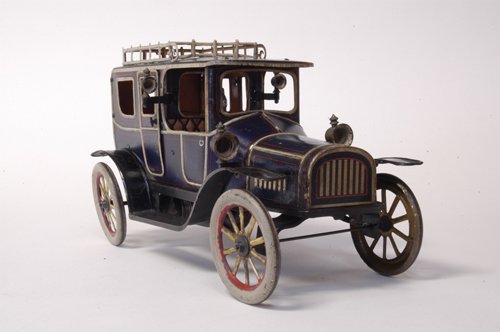 FISCHER LIMOUSINE: Germany, c.1915, lithographed tin, done in blue body, grey striping with ornate luggage rack, black running boards; spoke wheels painted in yellow and red, seated driver, cast head lamps and side lant