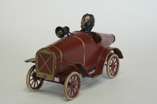 PINARD RACE CAR: France, circa 1905, an early open cockpit racer, handpainted in red with unusual solo electric head lamp on bonnet, clockwork driven, rubber tires, spoke wheels, added bisque head driver at wheel, gre
