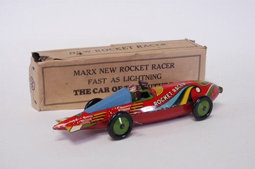 MARX BOXED ROCKET RACER: Lithographed tin with bright graphic colors, seated driver, windup action, well detailed tailfin section. 15 3/4'' long.