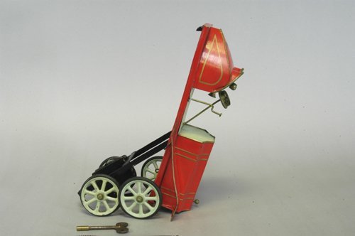 PINARD CLOCKWORK RACING CAR: Early 1900's, France, hand-painted tin, done red body, gold trim, green seating, well styled boat tail rear, spoke wheels, rubber tires, features steering wheel, and horn, lever under base makes racer