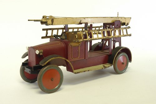 BING AERIAL LADDER TRUCK: Germany, third style in series, large scale, open bench seat and open service bed, contains extension ladder on trestle bed support, done in red with electric lights, tan ladder. 20 1/2'' long.