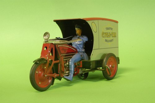 HOGE BOXED CYCLE CAR DELIVERY: Lithographed tin, great detail to this traffic delivery three-wheeler, seated driver, enclosed van body with opening rear doors, clockwork driven, exceptional condition. 10'' long.