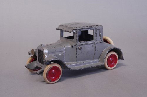 SKOGLUND & OLSEN CHEVROLET COUPE: C. late 1920's, cast iron, painted in grey overall, rubber tires, disc wheels done in red, spare mounted on trunk, silver trimmed radiator. 7 3/4'' long.