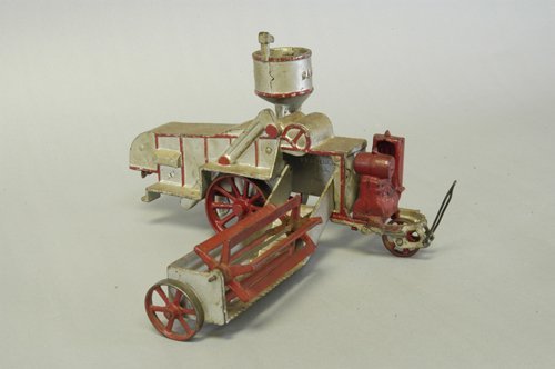 VINDEX CASE COMBINE: C. 1928, very rare farm toy, painted in silver overall, extensive red trim, exposed front engine, fold in cutter wheel, tall hopper, embossed ''CASE'' on sides. 12 1/4'' long.