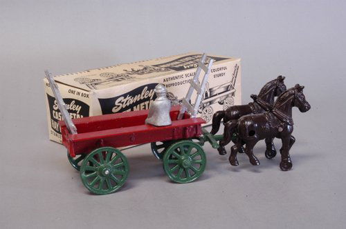 STANLEY BOXED HAY RACK WAGON: Die cast farm wagon, done in red open bed body, silver folding stake ends, green hitch and spoke wheels, team of brown horses, seated driver. 11'' long.