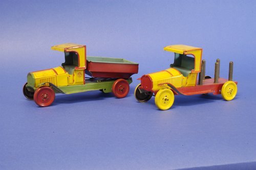 LOT OF TWO CHEIN TRUCKS: Lithographed tin, both done in yellow and red cabs, includes lumber truck and dump truck, both very colorful. 8 1/2'' long.