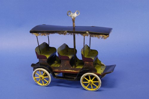 CONVERSE SIGHT SEEING BUS: Early pressed steel open trolley with three bench seats, painted in maroon and green seating, clockwork driven. Provenance: Gottschalk Collection. 11'' long.
