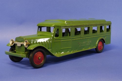 COR-COR BUS COACH STYLE: c. 1926, electric headlights, steel bumpers, rubber wheels, red painted centers, hump in roof model, very little wear to green painted body. 24''.