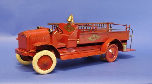 KELMET ''WHITE'' FIRE ENGINE: c. 1927, pressed steel, low open cab, bench seating, features open service bed with ladder and hose supports, railing leads to rear platform, white slip-over tires, disc wheels, decals on sides and ba
