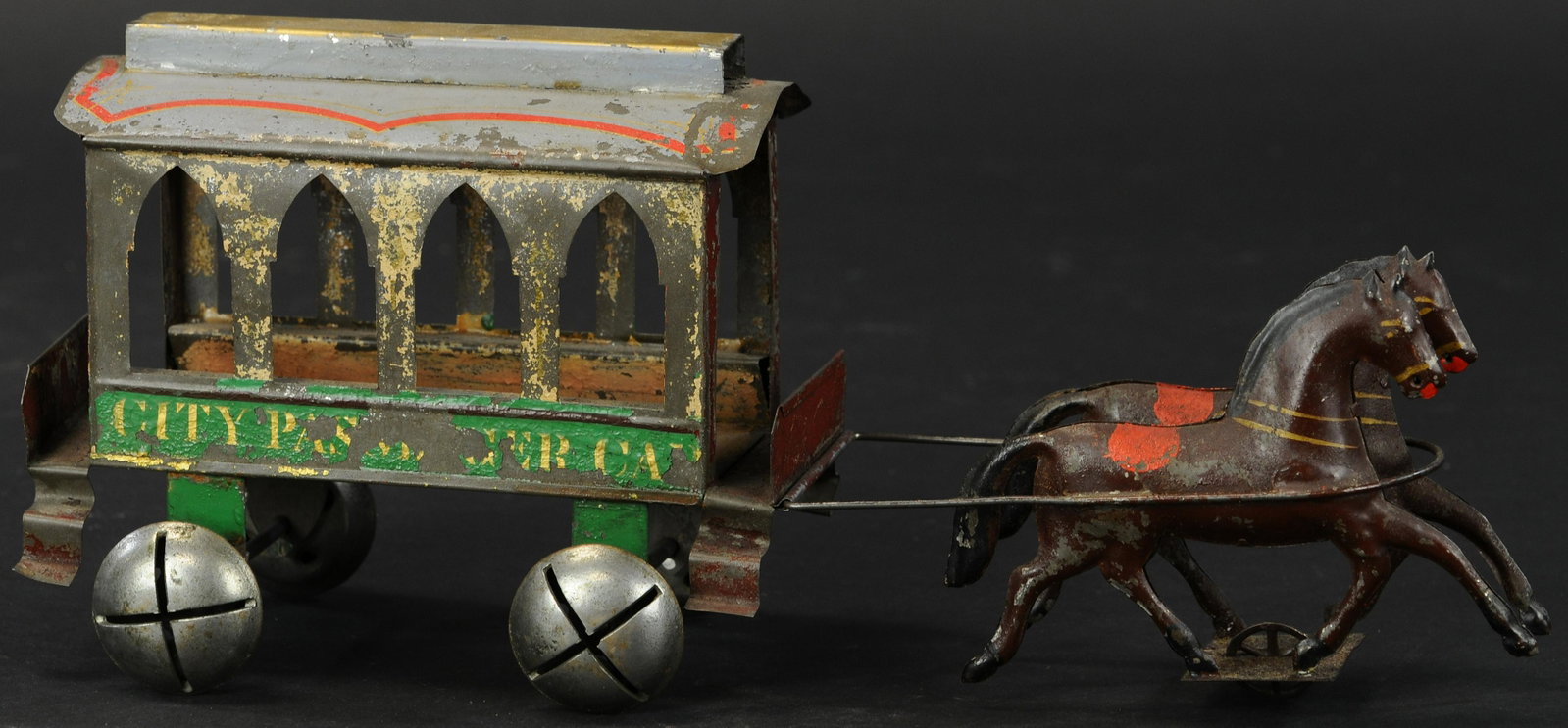 HULL & STAFFORD CITY TROLLEY CAR: 123. HULL & STAFFORD CITY TROLLEY CAR | An early and quite unusual hand painted American tin toy has chime bells for wheels, two horse team pulls decorative trolley car. Provenance: The Schroeder Coll