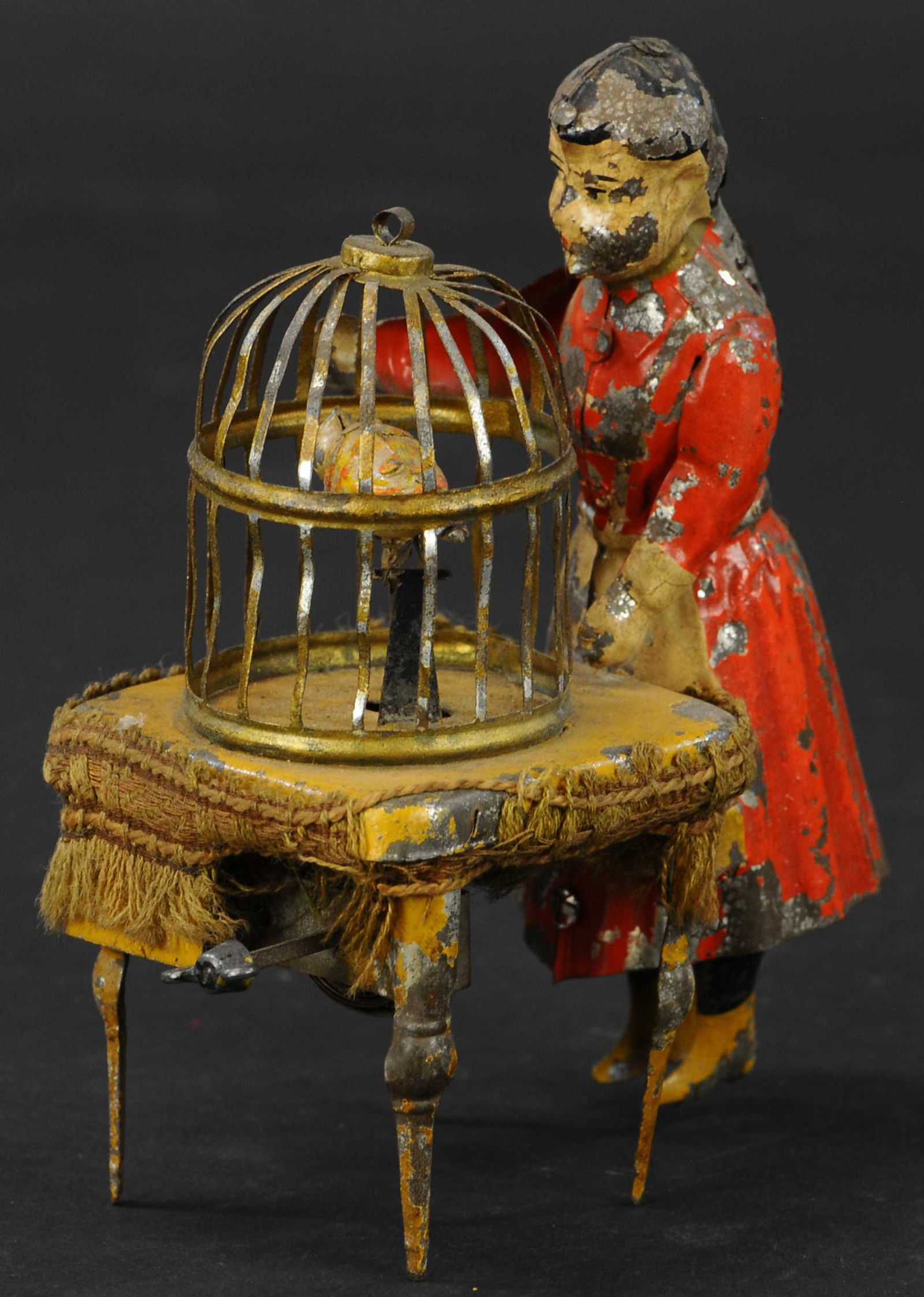 HANS EBERL GIRL AT BIRD CAGE: 369. HANS EBERL GIRL AT BIRD CAGE | Germany, an early and imaginative hand painted toy, when wound the girl's arm moves up and down, as the caged bird raises and lowers it's head, seemingly following