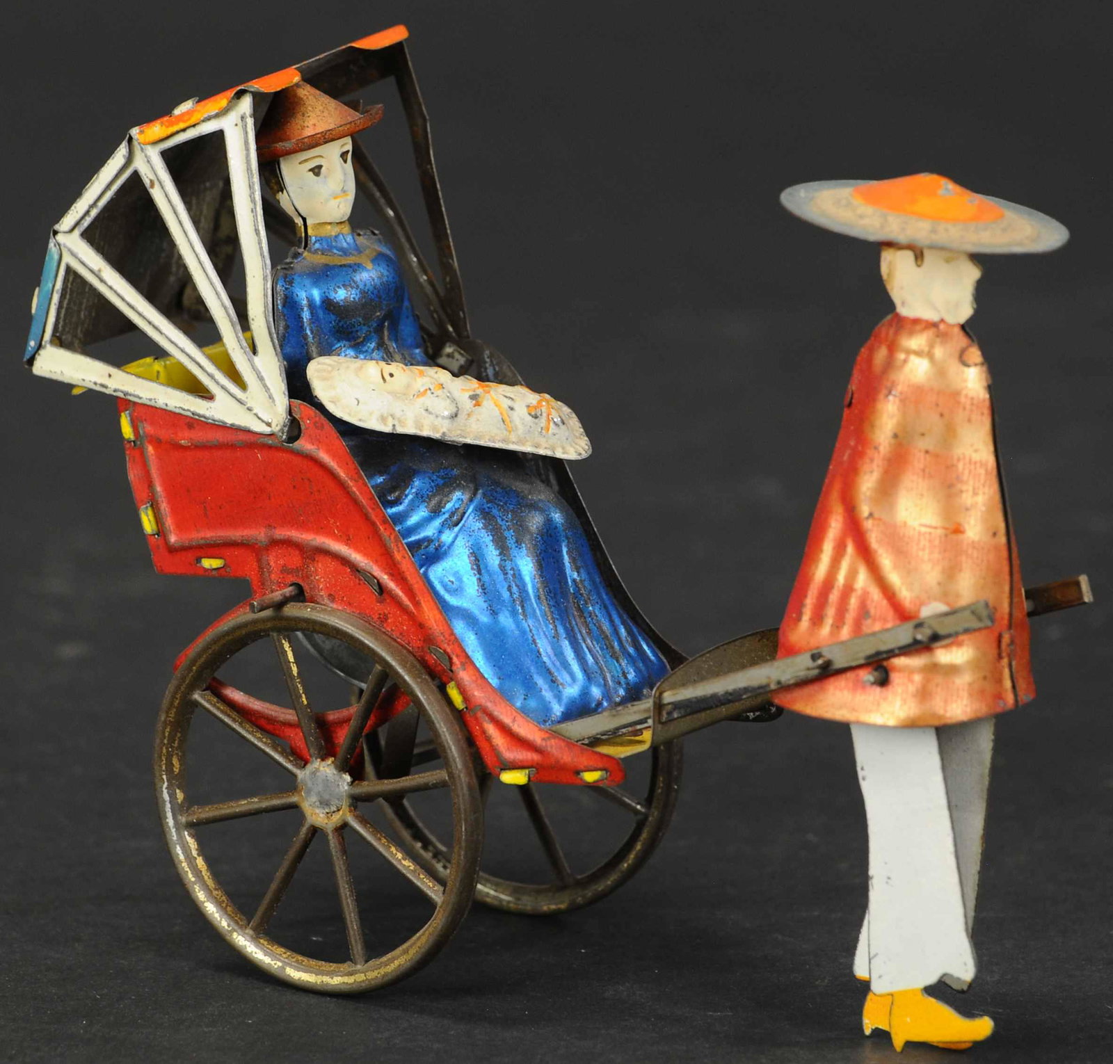LEHMANN MIKADO FAMILY: 409. LEHMANN MIKADO FAMILY | Germany, a very early example was produced as far back as 1894, interesting flywheel driven toy shows a man pulling rickshaw with woman rocking child in arms. Provenance: 