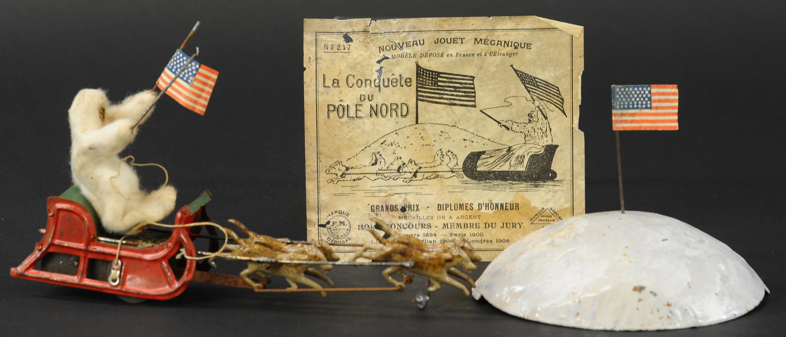 MARTIN ADMIRAL PEARY DOG SLED: 427. MARTIN ADMIRAL PEARY DOG SLED | France, includes seldom seen box lid label, c. 1909, "La Conquete du Pole Nord", includes original snow mound with flag and a string with hook at end to cause a ci