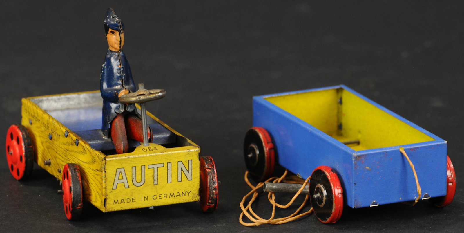 TWO LEHMANN WAGONS: AUTIN AND BIBI: 496. TWO LEHMANN WAGONS: AUTIN AND BIBI | Germany, boy in "Autin" has wind-up motor, "Bibi" has string to pull.. Provenance: The Schroeder Collection. | 4" l. | (Excellent Condition) | $200 - $400