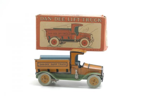 BOXED CHEIN "DAN DEE" DUMP TRUCK: Old store stock, lithographed tin, done in orange body, blue bed, green fenders, key wind mechanism, box depicts several "Dan Dee" trucks. 8 3/4" l.
