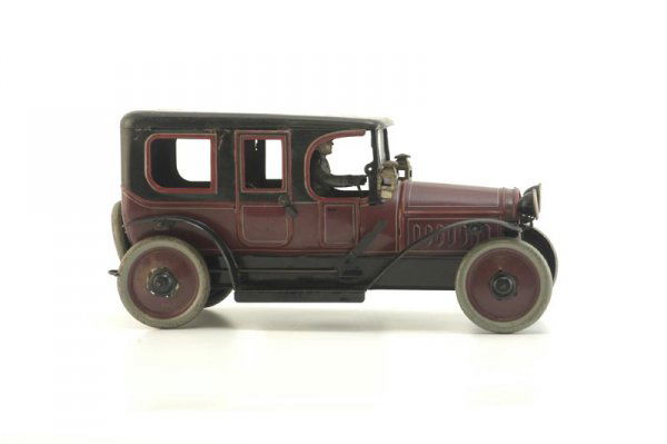 KARL BUB LIMOUSINE: Germany, late teens example, lithographed tin, done in rich brown, black roof, red trim, side lanterns, head lamps and seated driver in enclosed chauffeur's compartment, doors open, clockwork driven.