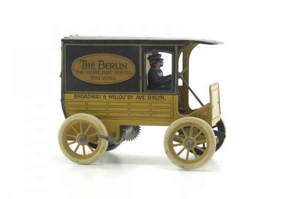 HANS EBERL "BERLIN STORE" DELIVERY VAN: Germany, c. 1920's, lithographed tin, done in yellow and black body, familiar simulated stake body reads "The Berlin," a Brooklyn, NY store, clockwork driven, seated driver, opening rear doors. 7" l.