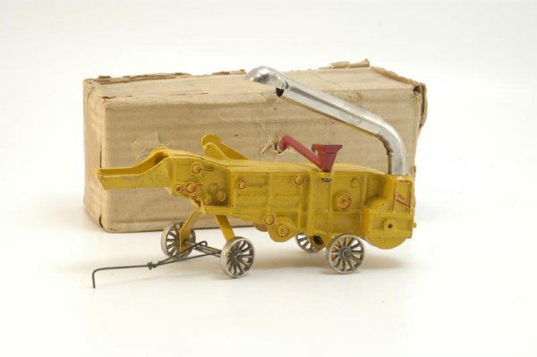 ARCADE BOXED MC CORMICK DEERING THRESHER: c. 1930, cast iron, painted in yellow overall, nickel plated stacker, red grain pipe, nickel spoke wheels, cast bundle apron. 9 1/4" l.